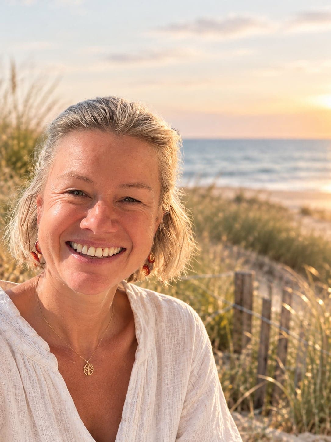 Catherine De Groote, souriante, dans les dunes au coucher du soleil